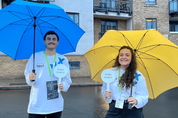 4-min two people holding signs showing where the google cloud event is